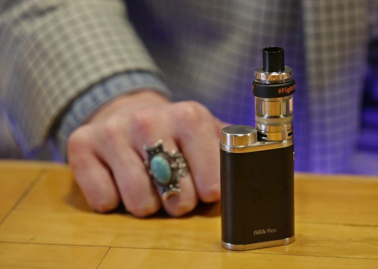 FILE - This March 15, 2017 file photo shows a vape belonging to Branden Kempt, who works at the Future Vapor store in Seattle, rests on the store's counter. Legislators in Washington state have approved on Wednesday, March 27, 2019, a bill to raise the smoking and vaping age there to 21, sending it to Gov. Jay Inslee for his signature. Supporters say the measure would help eliminate youth smoking, but at least one national anti-tobacco group has criticized its enforcement mechanisms. (AP Photo/Ted S. Warren, File)