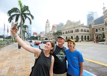 from L-R, Hannah Lins, Dennis Lins and Lori Lins from USA wefie with the backaground of Malaysian iconic building Sultan Abdul Samad in Kuala Lumpur
(11/6/2022). —AZHAR MAHFOF/The Star